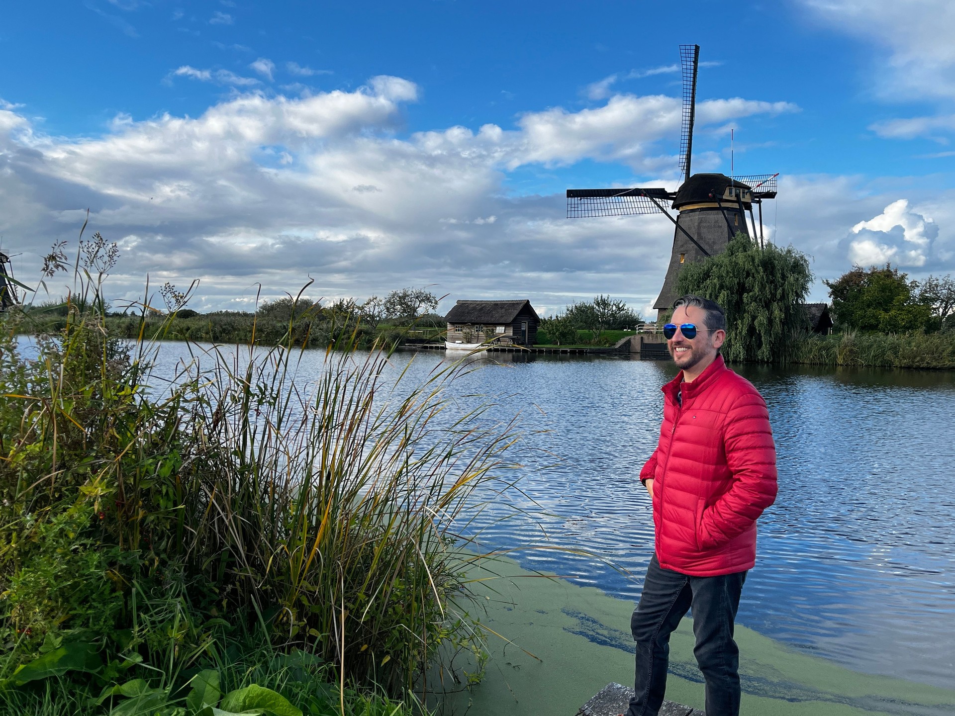 Happiness young latin male tourist taking a euro trip around Windmills in Kinderdijk, South Holland, Netherlands.