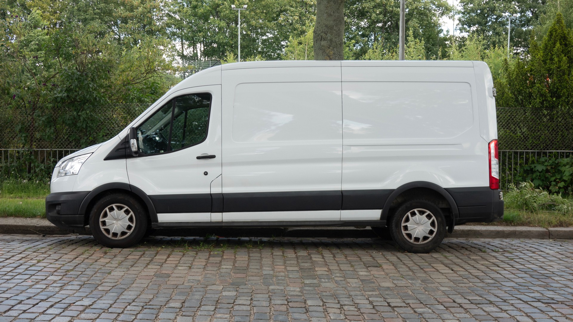 White Delivery Van Parked on Cobblestone Street